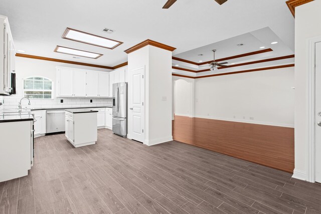 8010 Village Dr, Beaumont, TX 77713 - kitchen featuring stainless steel appliances, a ceiling fan, crown molding, open floor plan, and a kitchen island