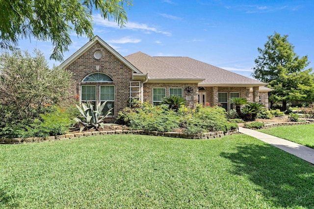 8010 Village Dr, Beaumont, TX 77713 - view of front facade featuring a front lawn, brick siding, and roof with shingles
