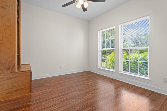 8010 Village Dr, Beaumont, TX 77713 - empty room featuring a ceiling fan, dark wood-type flooring, and baseboards
