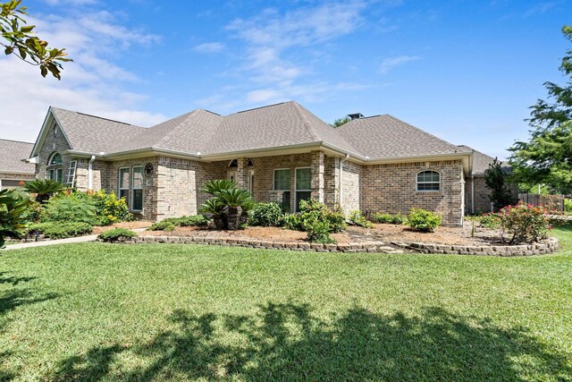 8010 Village Dr, Beaumont, TX 77713 - view of front of home featuring brick siding, a front yard, and roof with shingles
