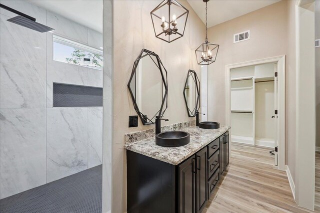 102 Timbercreek Dr, Lumberton, TX 77657 - full bathroom featuring a marble finish shower, wood finished floors, double vanity, a chandelier, and a spacious closet