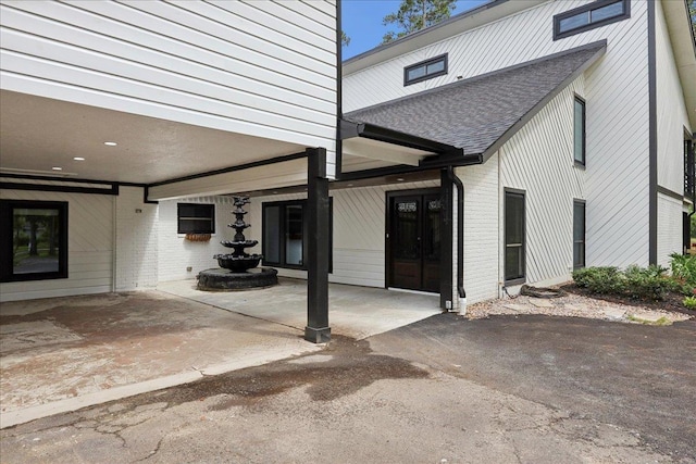 102 Timbercreek Dr, Lumberton, TX 77657 - entrance to property with a shingled roof, brick siding, and a carport