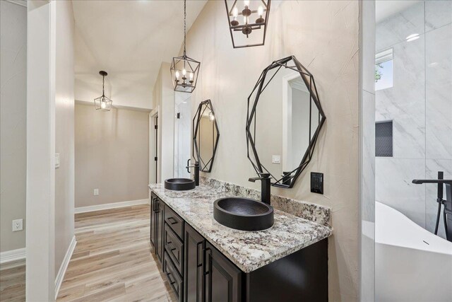 102 Timbercreek Dr, Lumberton, TX 77657 - full bath featuring double vanity, a chandelier, wood finished floors, and a freestanding tub