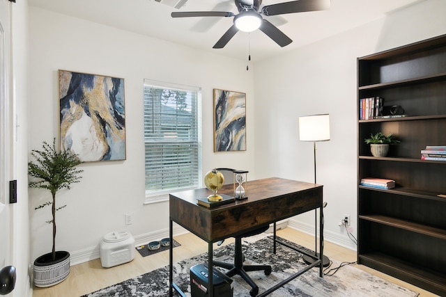 office space featuring a ceiling fan, baseboards, and wood finished floors