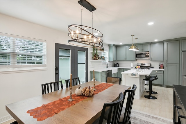 dining area with light wood finished floors, french doors, recessed lighting, and a healthy amount of sunlight