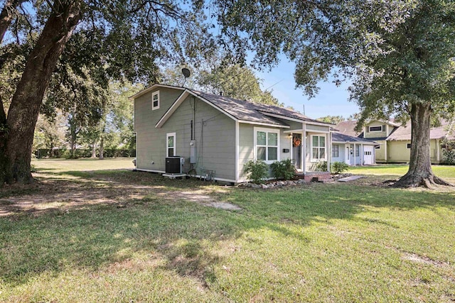 view of front of property featuring cooling unit and a front yard