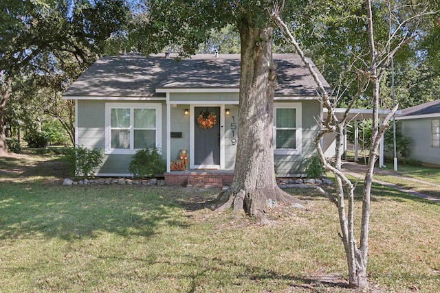 view of front facade featuring roof with shingles and a front yard