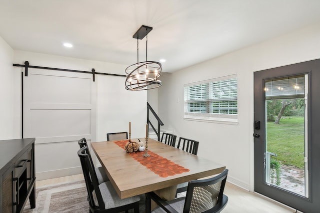 dining space with baseboards, a barn door, recessed lighting, and light wood-style floors