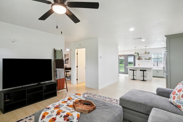 living area featuring recessed lighting, visible vents, ceiling fan, light wood-type flooring, and baseboards