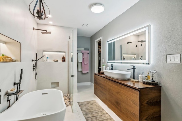 full bath featuring vanity, a textured wall, a soaking tub, visible vents, and a walk in shower