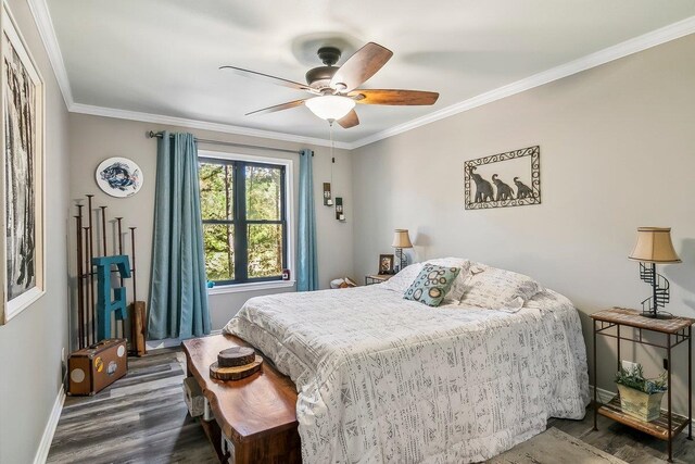 bedroom with dark wood-style floors, baseboards, ornamental molding, and a ceiling fan