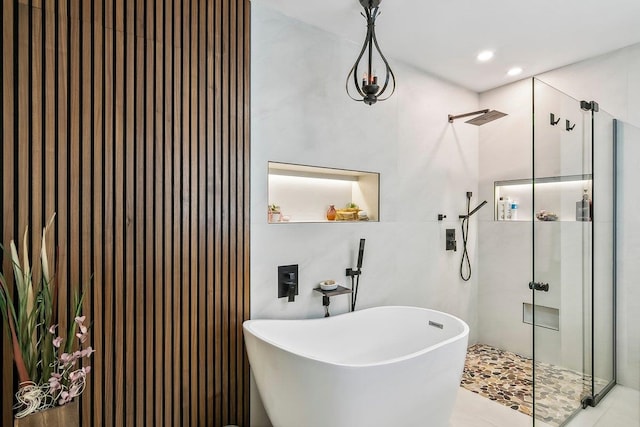 bathroom with a freestanding tub, a stall shower, and recessed lighting