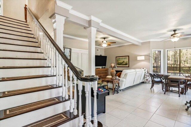 interior space featuring light tile patterned floors, ceiling fan, stairway, and ornamental molding
