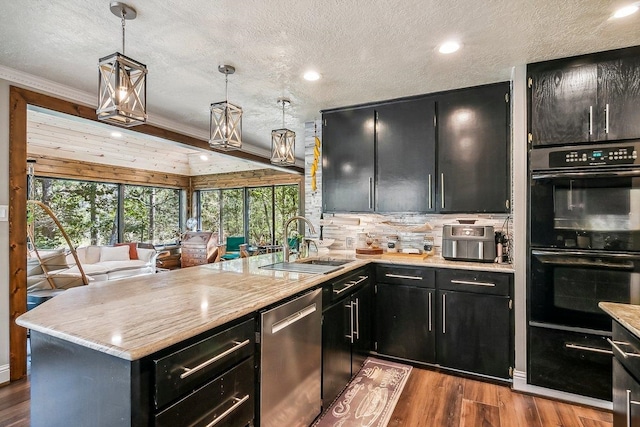 kitchen with a peninsula, dobule oven black, a sink, dark cabinets, and stainless steel dishwasher
