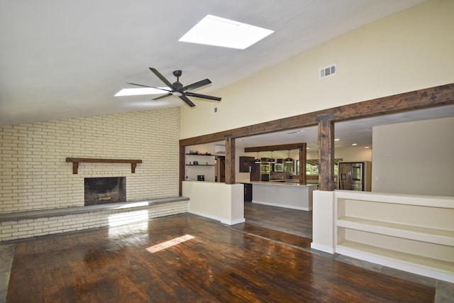 90 Blanton Rd, Lumberton, TX 77657 - unfurnished living room featuring a skylight, lofted ceiling, a brick fireplace, wood finished floors, and ceiling fan