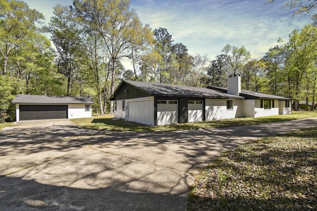 90 Blanton Rd, Lumberton, TX 77657 - view of home's exterior with a chimney, a garage, view of scattered trees, and an outbuilding