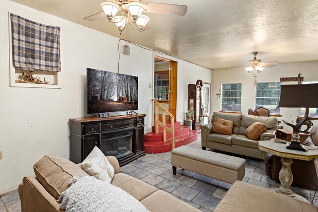 6531 Childress Ln, Kountze, TX 77625 - living room featuring ceiling fan, a glass covered fireplace, and stairway