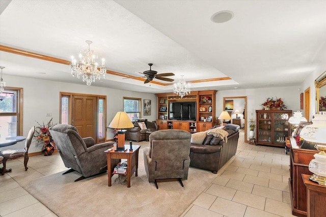 living room featuring ceiling fan with notable chandelier, a raised ceiling, a wealth of natural light, and light tile patterned flooring