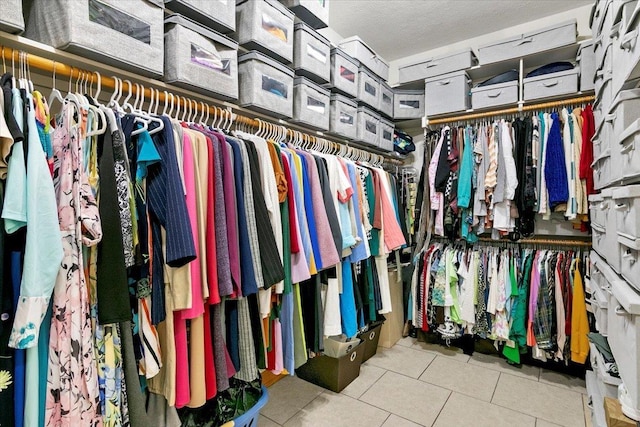 walk in closet with light tile patterned floors