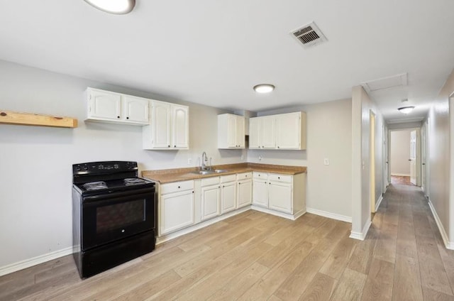504 David Dr, Bridge City, TX 77611 - kitchen with black range with electric cooktop, a sink, light wood-style flooring, and white cabinetry