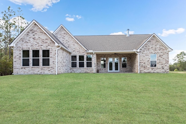 rear view of property featuring a lawn and french doors