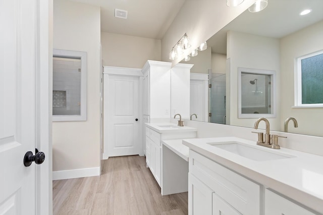 bathroom with a shower with door, vanity, and hardwood / wood-style floors