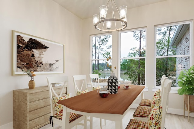 dining room with plenty of natural light, light hardwood / wood-style flooring, and an inviting chandelier