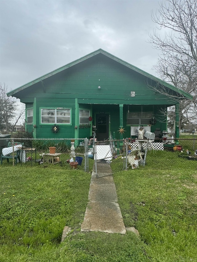 view of front facade featuring a front lawn, a fenced front yard, and a gate