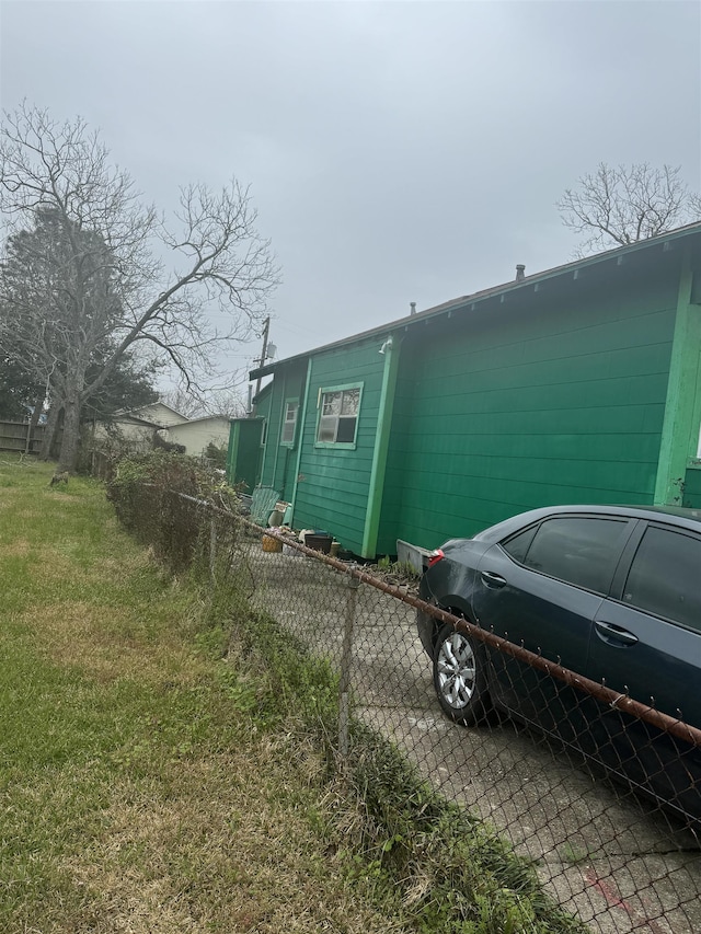 view of side of home featuring a yard and fence