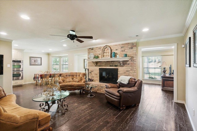 living room with dark hardwood / wood-style floors, a healthy amount of sunlight, ceiling fan, and a brick fireplace