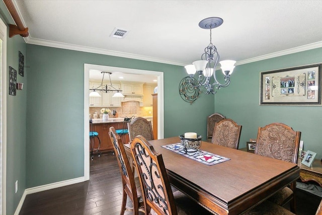 dining room with dark hardwood / wood-style flooring, a chandelier, and ornamental molding