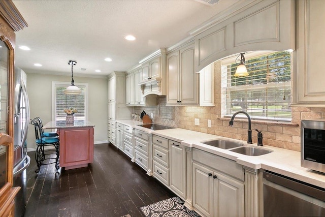 kitchen featuring appliances with stainless steel finishes, dark hardwood / wood-style flooring, backsplash, sink, and pendant lighting