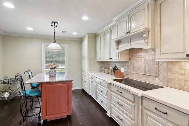 kitchen with dark hardwood / wood-style floors, decorative light fixtures, black electric cooktop, a breakfast bar, and a kitchen island