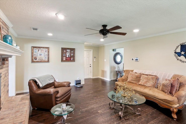 living room featuring dark wood-type flooring, crown molding, ceiling fan, a textured ceiling, and a fireplace