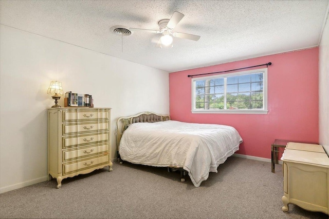 carpeted bedroom featuring ceiling fan and a textured ceiling