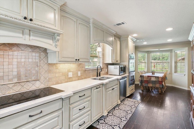 kitchen featuring sink, dark hardwood / wood-style floors, ornamental molding, appliances with stainless steel finishes, and tasteful backsplash