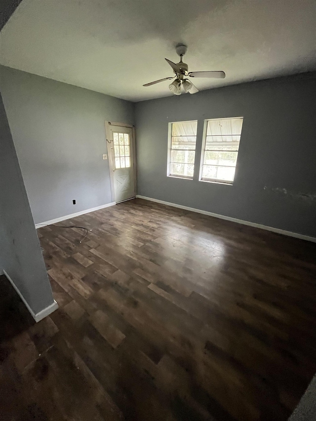 empty room with dark hardwood / wood-style floors and ceiling fan