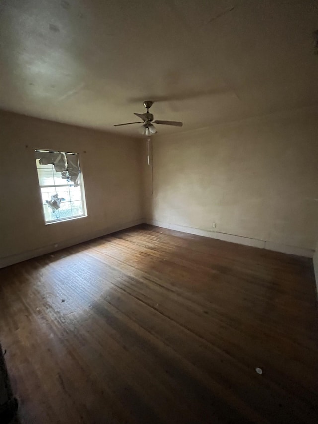 empty room featuring ceiling fan and dark wood-type flooring