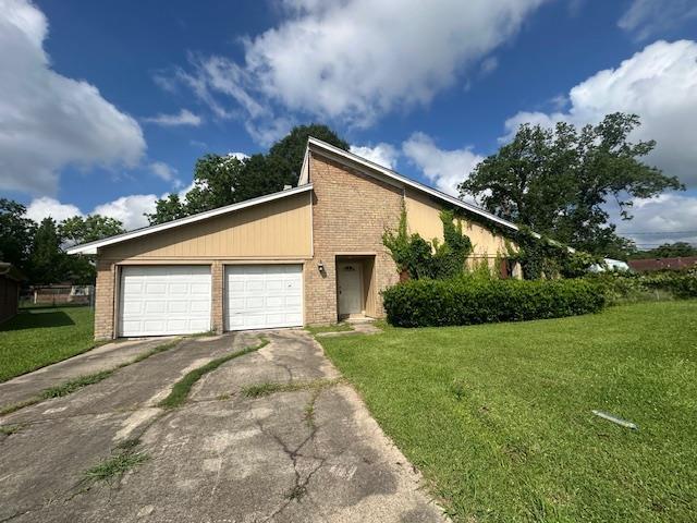5935 Falcon Ln, Beaumont, TX 77708 - view of front of home featuring brick siding, driveway, a front lawn, and an attached garage
