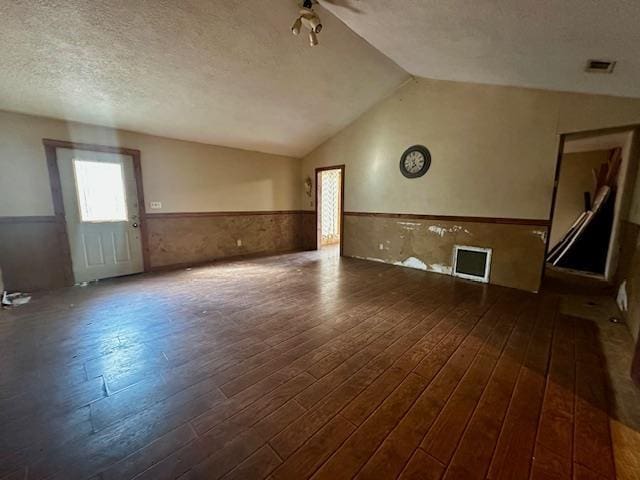 unfurnished room featuring vaulted ceiling, dark wood-type flooring, ceiling fan, and a textured ceiling