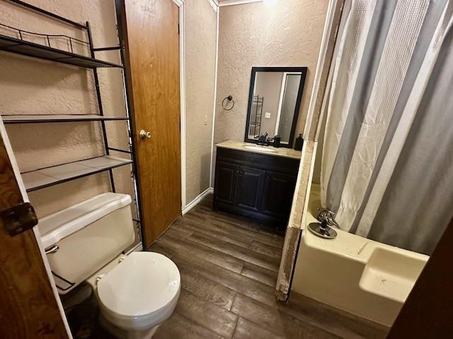 full bathroom featuring shower / bath combination with curtain, wood-type flooring, vanity, and toilet