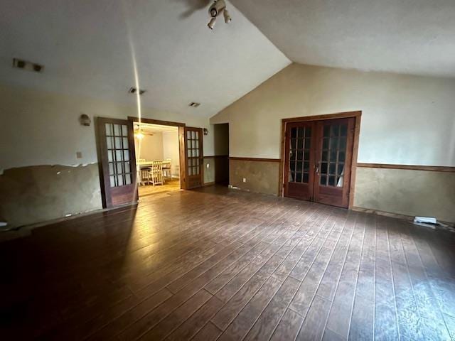 unfurnished living room featuring dark hardwood / wood-style flooring, lofted ceiling, and french doors