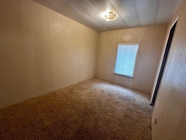 carpeted spare room featuring a textured ceiling