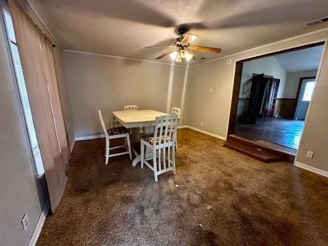 carpeted dining space featuring crown molding and ceiling fan