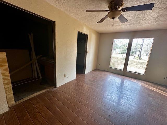 spare room with hardwood / wood-style flooring, ceiling fan, and a textured ceiling