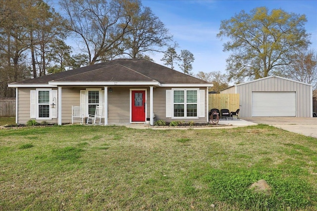 ranch-style house featuring a detached garage, fence, a front yard, an outbuilding, and driveway