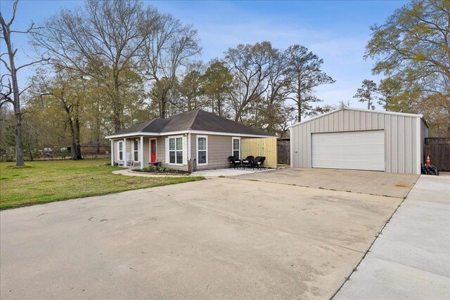 view of front of home with an outbuilding, a detached garage, and a front yard