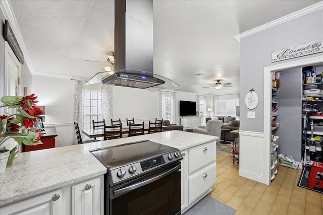 kitchen featuring ornamental molding, electric stove, a textured ceiling, island range hood, and ceiling fan