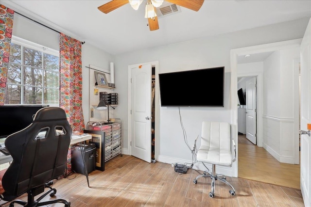 office space featuring ceiling fan, visible vents, and light wood-style flooring