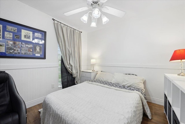 bedroom featuring ceiling fan, dark wood finished floors, and wainscoting